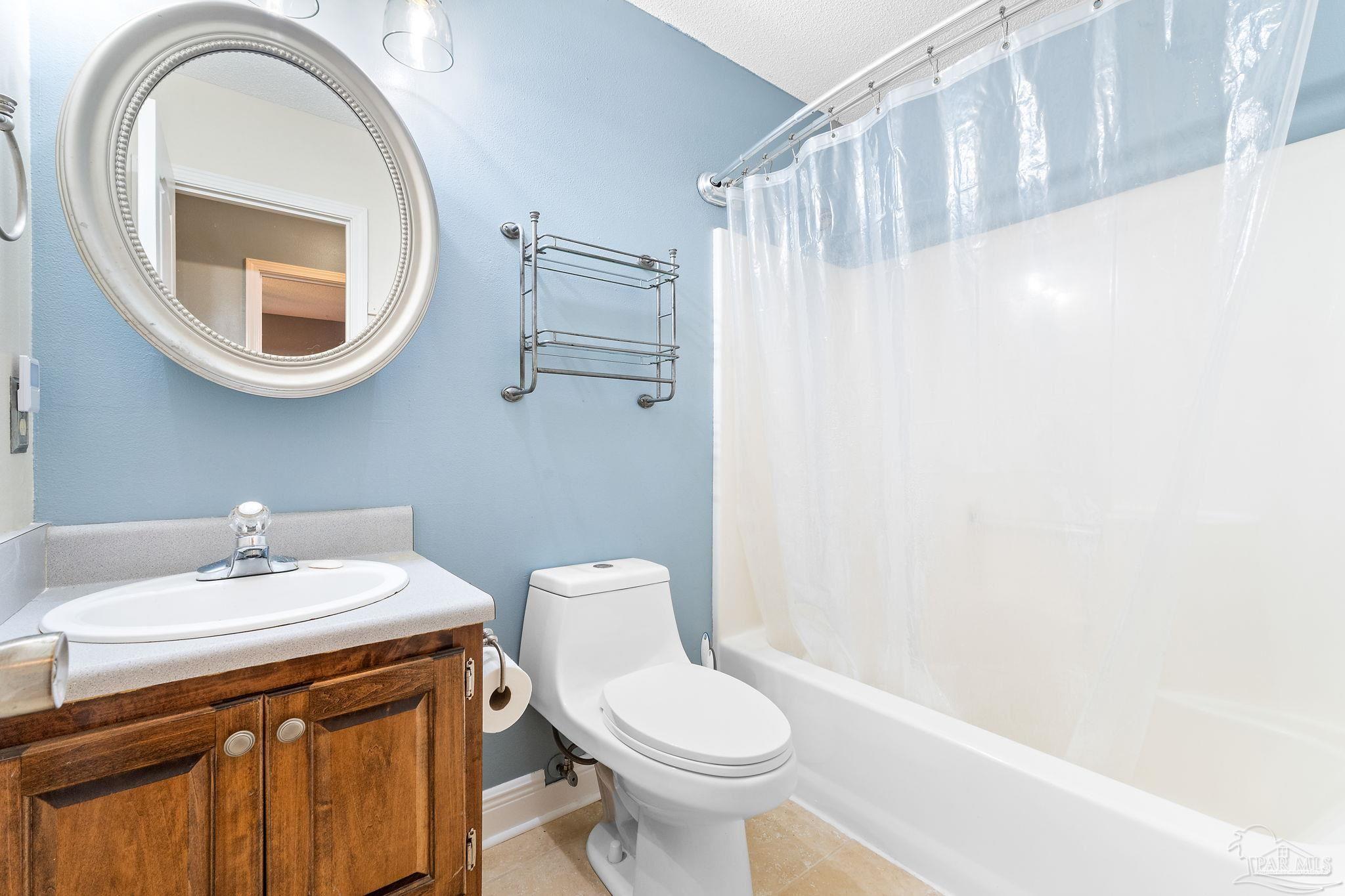 5645 Windham Road Milton, FL 32570 - Photo 26 of 40 a bathroom with a sink a toilet and a mirror