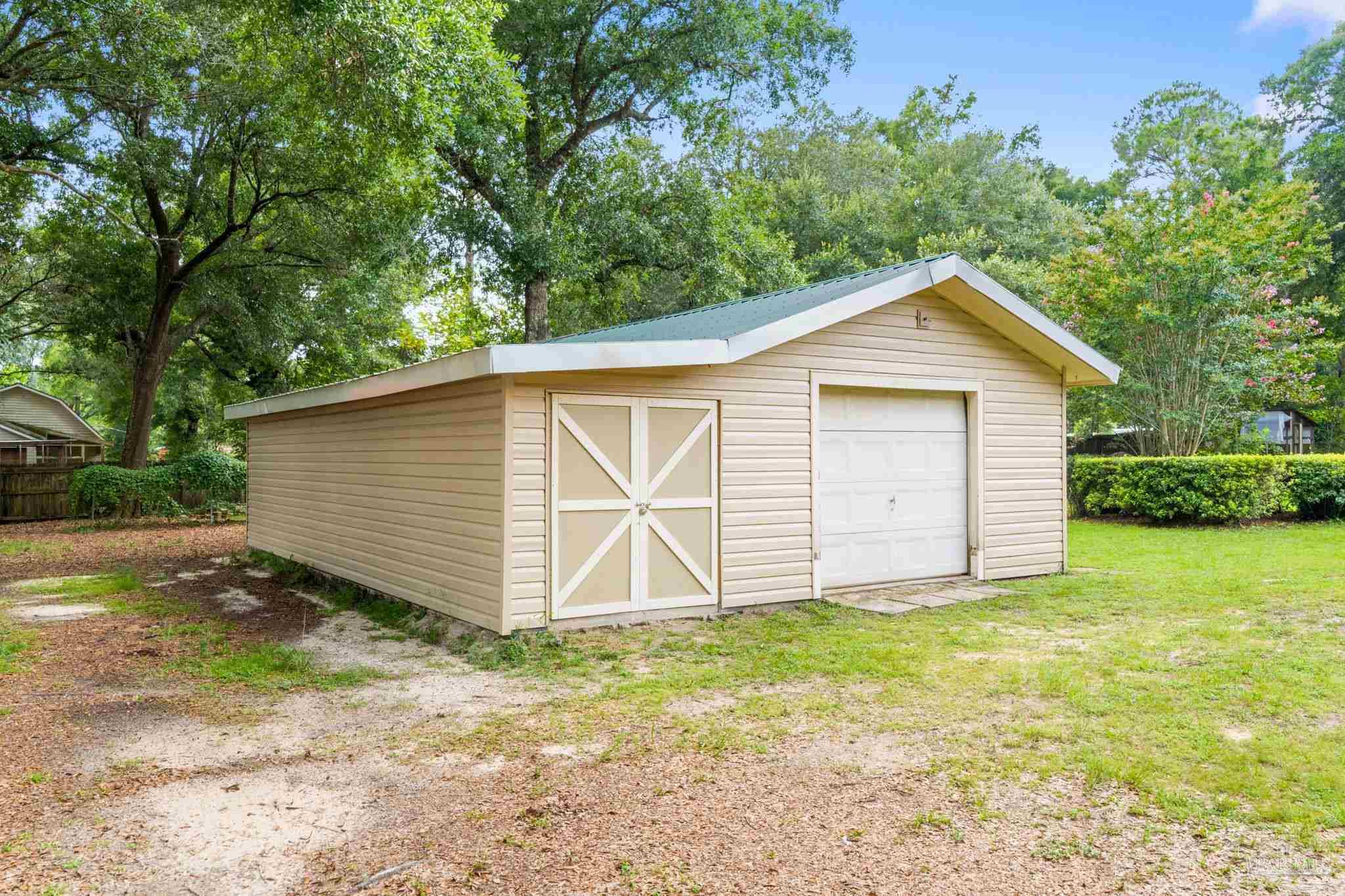 5645 Windham Road Milton, FL 32570 - Photo 28 of 40 a view of a house with a yard and garage