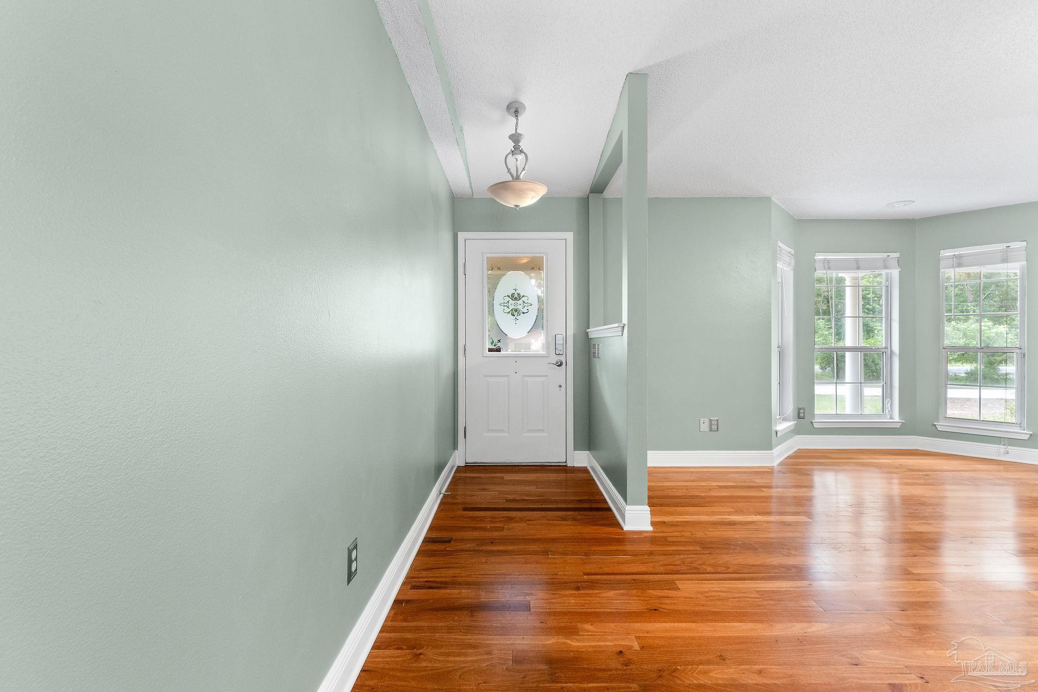 5645 Windham Road Milton, FL 32570 - Photo 5 of 40 a view of a hallway with wooden floor and a large window