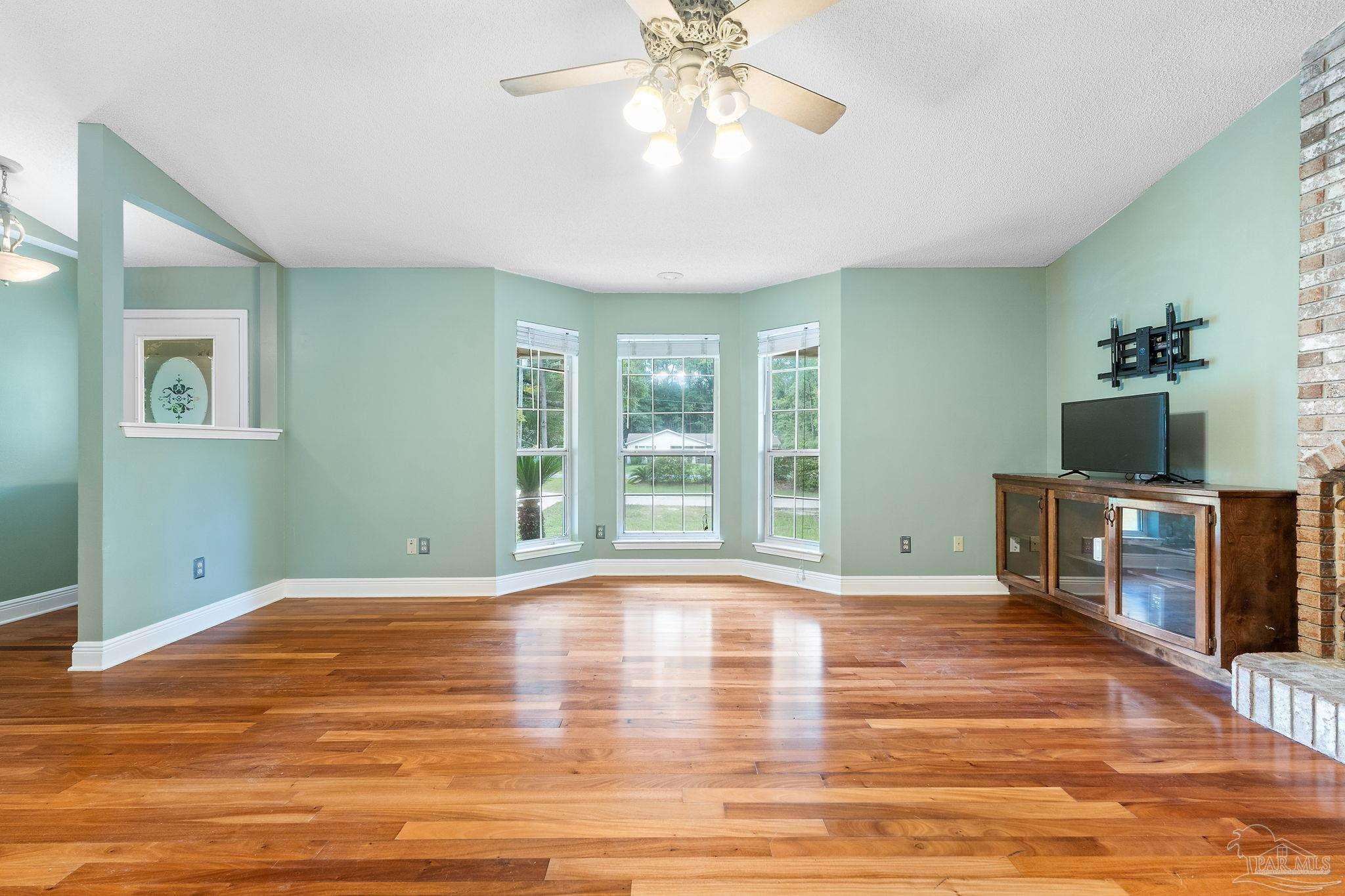 5645 Windham Road Milton, FL 32570 - Photo 7 of 40 a view of an empty room with window and wooden floor