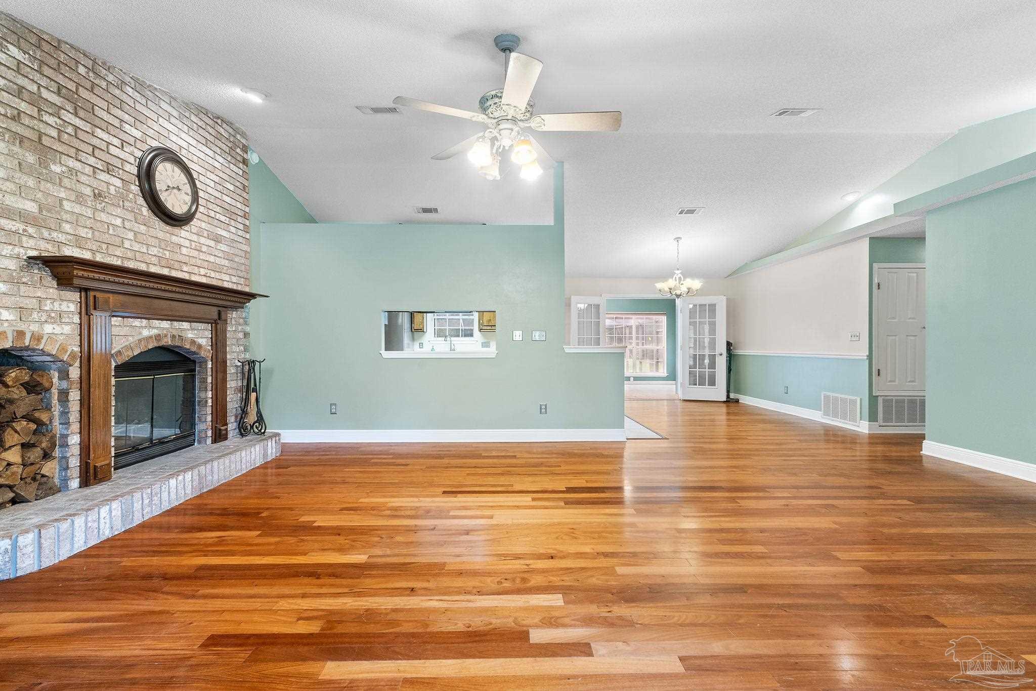 5645 Windham Road Milton, FL 32570 - Photo 8 of 40 a view of empty room with wooden floor and fireplace