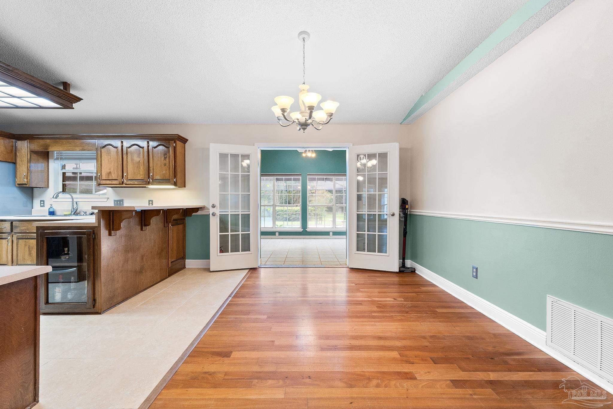 5645 Windham Road Milton, FL 32570 - Photo 10 of 40 a view of a kitchen with granite countertop natural light wood floor and a chandelier