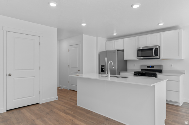 1907 East 640th North, Unit 1225 Salem, UT 84653 - Photo 19 of 20 Modern kitchen featuring white cabinetry, stainless steel appliances, a center island with a sink, recessed lighting, and wood-finish flooring