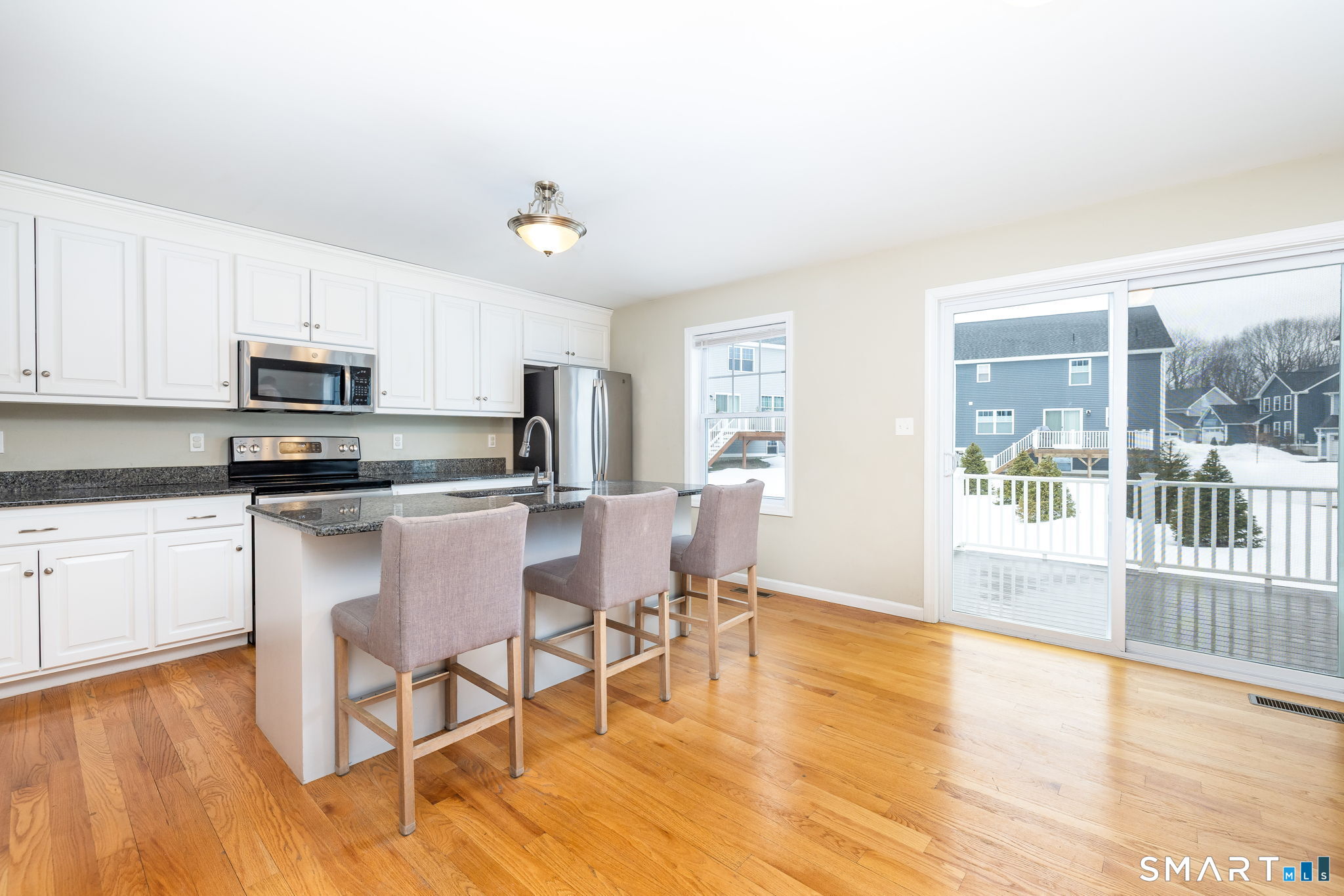 365 Allentown Road, Unit 34 Bristol, CT 06010 - Photo 14 of 43 a kitchen with granite countertop a stove a sink dishwasher a refrigerator with white cabinets and wooden floor next to a window
