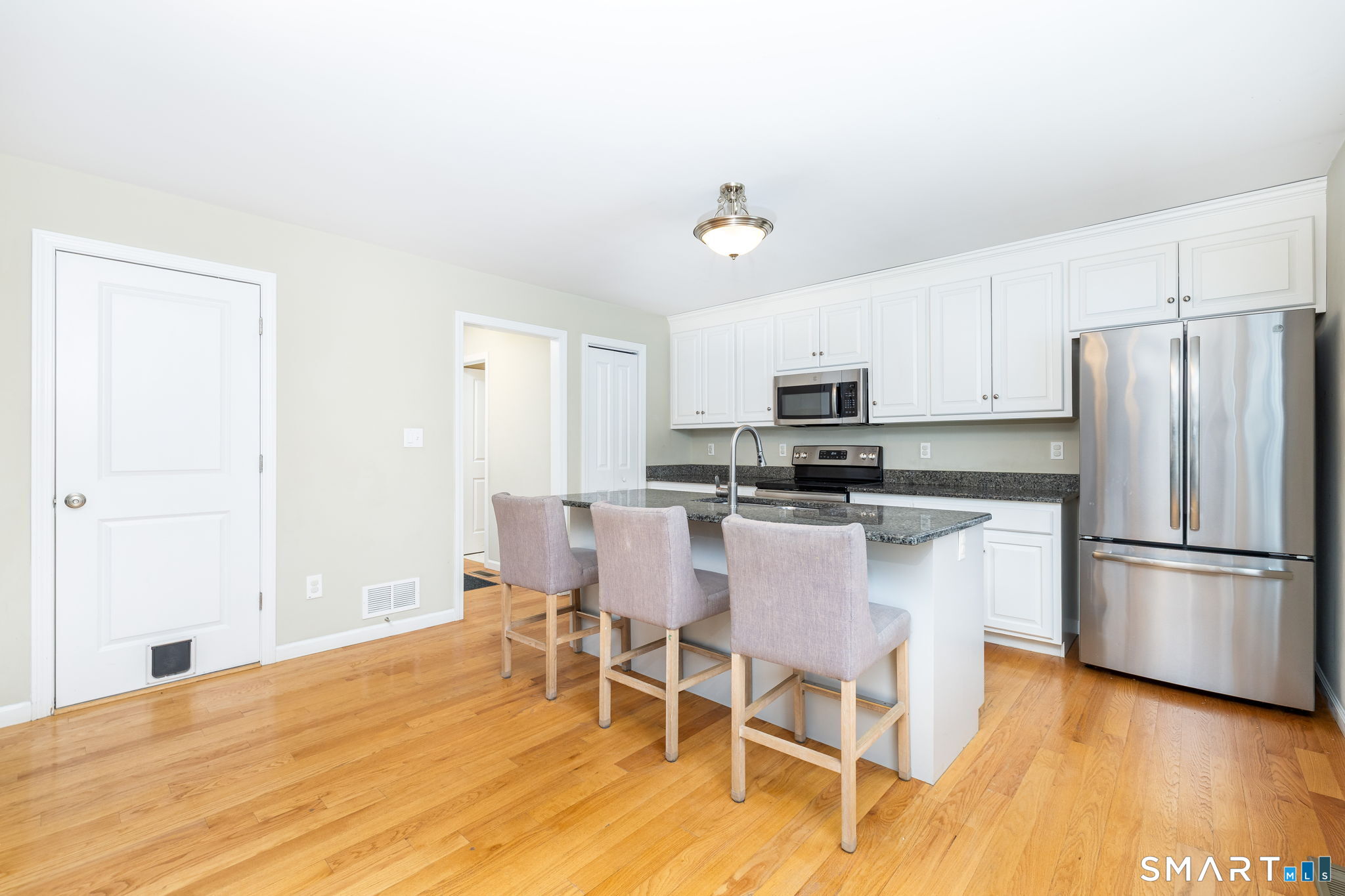 365 Allentown Road, Unit 34 Bristol, CT 06010 - Photo 15 of 43 a kitchen with stainless steel appliances granite countertop a stove a refrigerator a microwave oven with a dining table and chairs