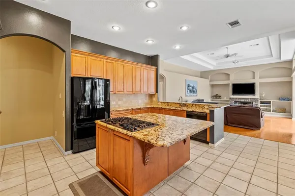 a kitchen with stainless steel appliances granite countertop a stove top oven island a table and chairs