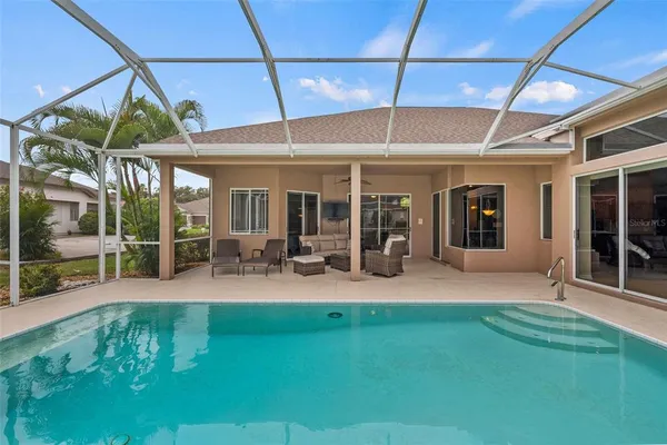 a view of a house with swimming pool and sitting area