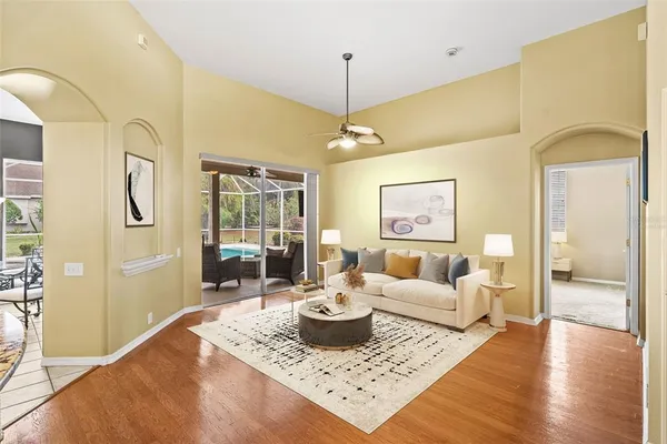 a hallway with a large window wooden floor and couch