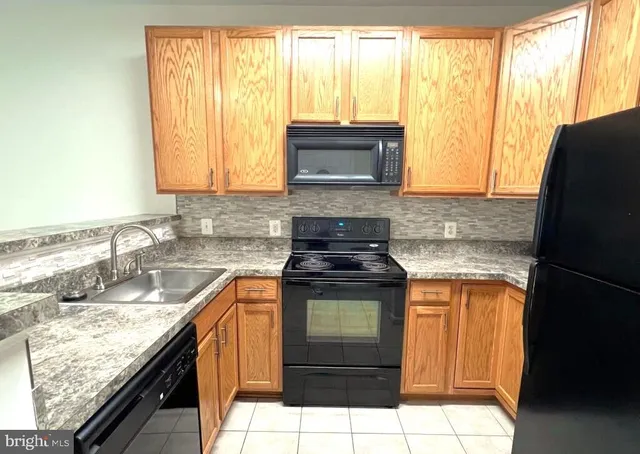 a kitchen with granite countertop a sink stove and cabinets