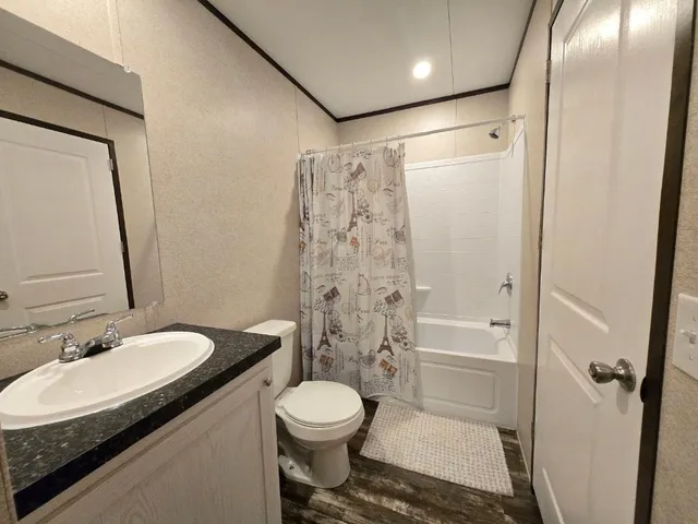 a bedroom with a bed and a lamp on dresser