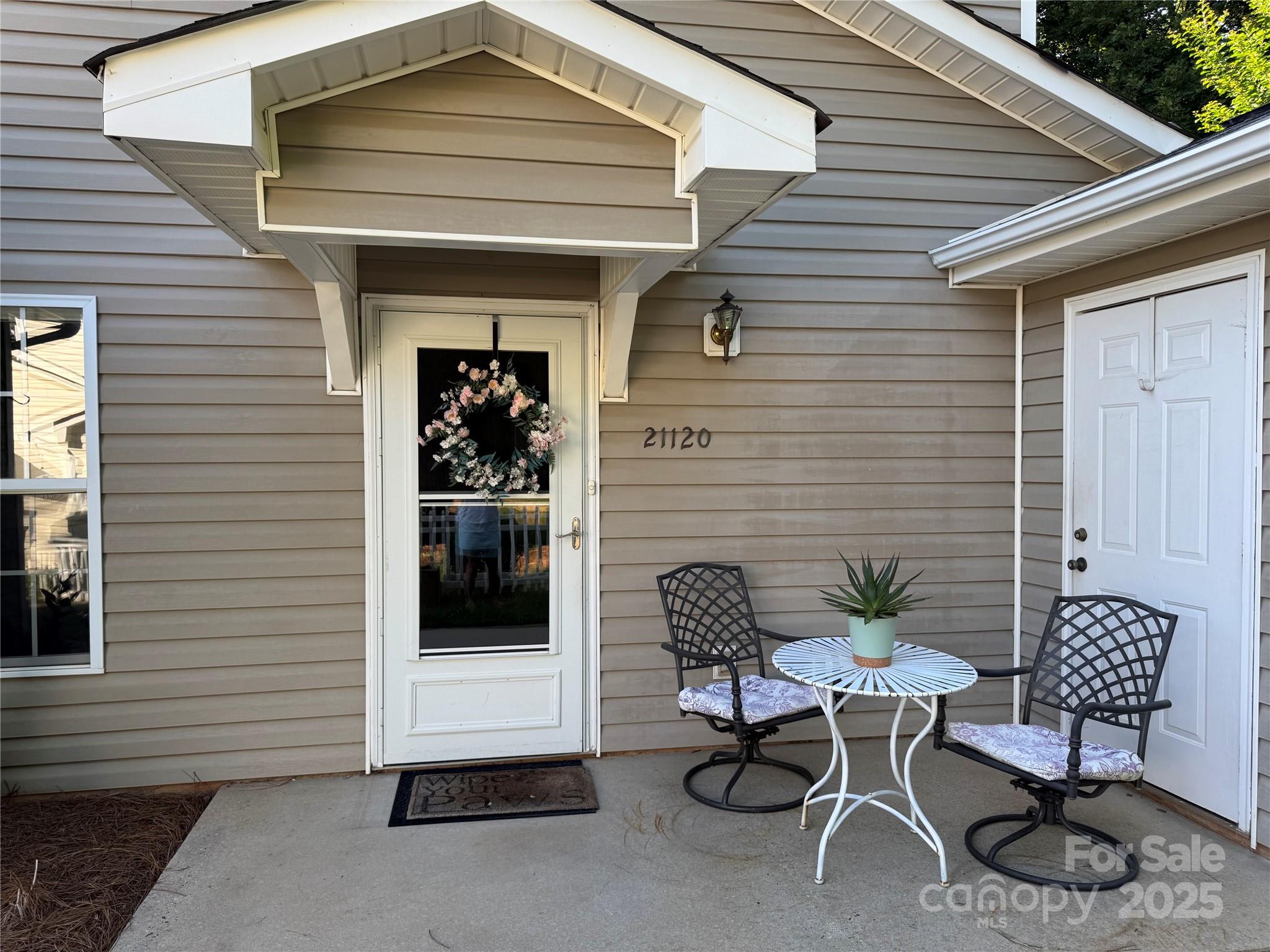 21120 Cold Spring Lane Cornelius, NC 28031 - Photo 2 of 22 a view of a patio with a table and chairs and potted plants