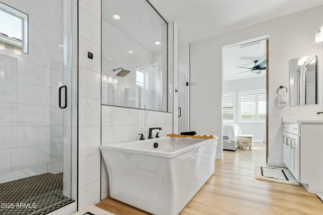 a spacious bathroom with a sink a mirror a vanity and a bathtub
