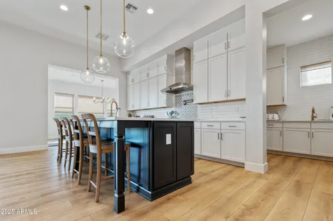 a large white kitchen with lots of counter space and stainless steel appliances