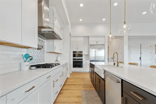 a kitchen with kitchen island a counter space a stove a sink and cabinets