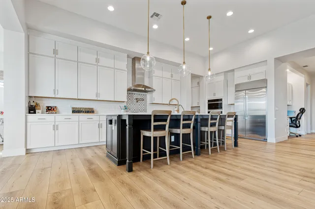 a large white kitchen with lots of counter space and stainless steel appliances