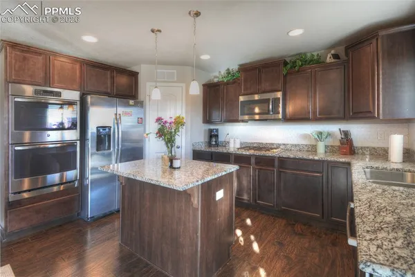 a kitchen with stainless steel appliances granite countertop a sink refrigerator and microwave