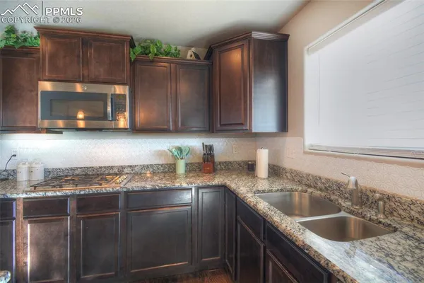 a kitchen with stainless steel appliances granite countertop a sink stove and microwave
