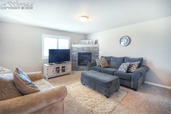 a living room with furniture a flat screen tv and a fireplace