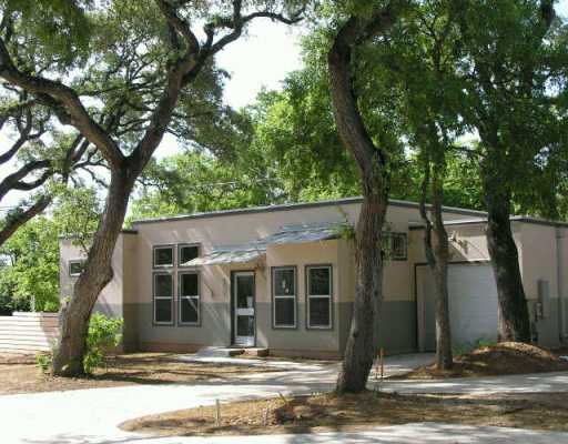 a front view of a house with a tree