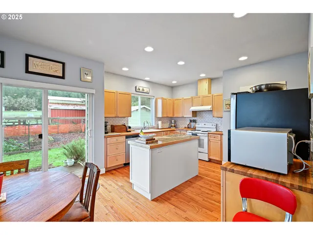 a living room with stainless steel appliances furniture and a large window