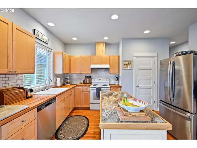 a kitchen with stainless steel appliances granite countertop a sink refrigerator and stove