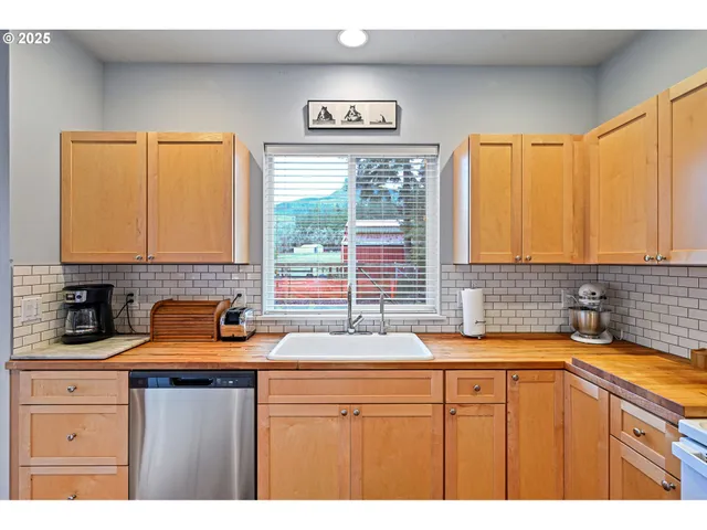 a kitchen with stainless steel appliances a sink a stove and a window
