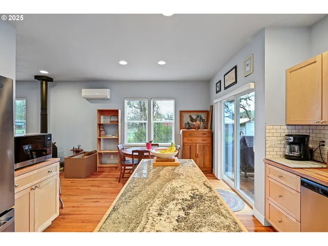 a very nice looking open kitchen with granite countertop a large window
