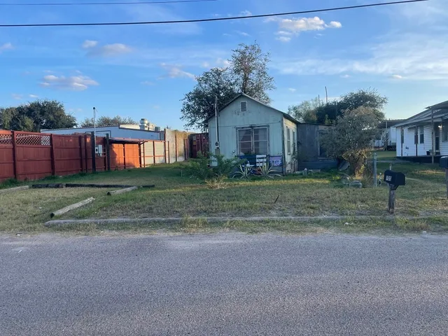 a front view of a house with a yard and trees
