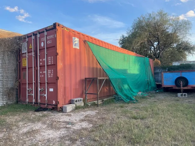 a view of a backyard with potted plants and a barbeque