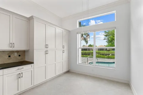 a kitchen with white cabinets and a window