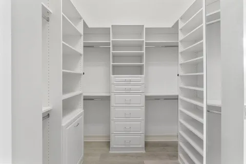 a view of walk in closet with empty racks