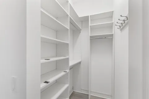 a view of walk in closet with empty racks
