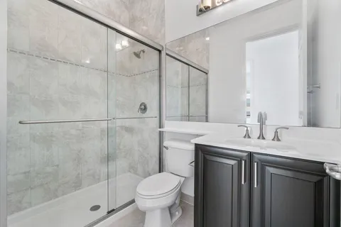 a bathroom with a granite countertop sink toilet and shower