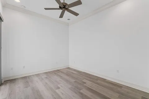 a view of a room with wooden floor and a ceiling fan