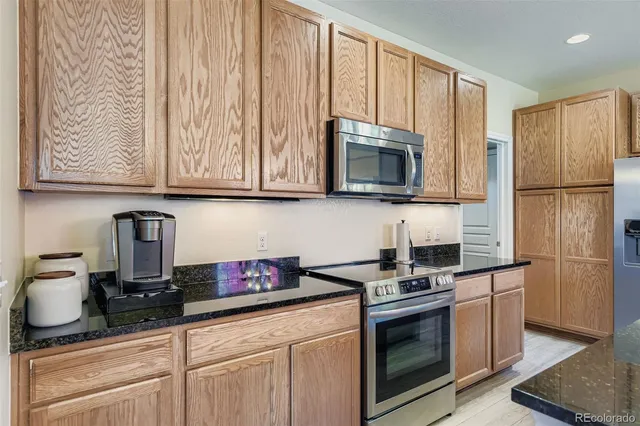 a kitchen with granite countertop cabinets stainless steel appliances and wooden floor