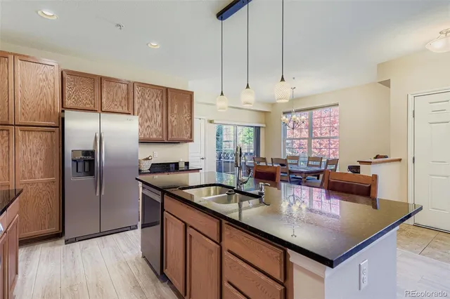 a kitchen with stainless steel appliances granite countertop a sink a stove and refrigerator