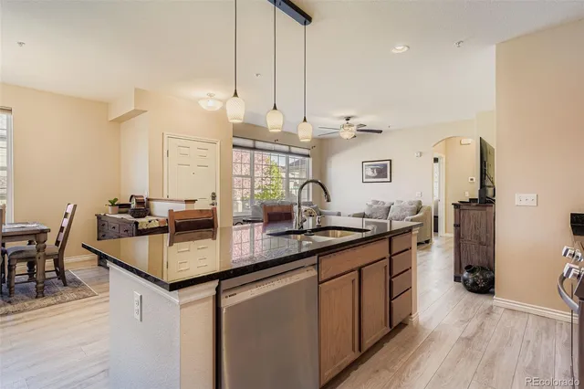 a kitchen with kitchen island granite countertop a sink cabinets and wooden floor