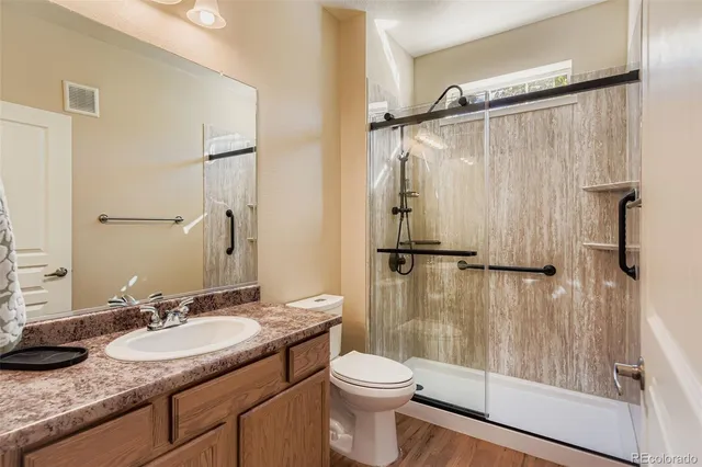 a bathroom with a granite countertop sink toilet and shower