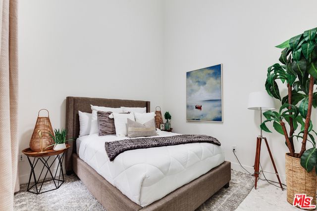 a bedroom with a bed and a potted plant
