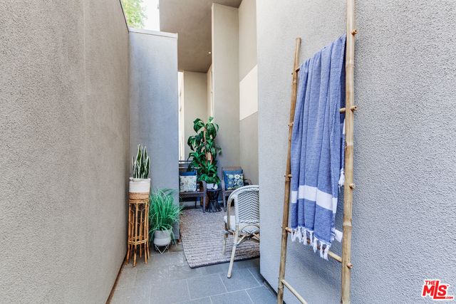 a view of a hallway with chairs and potted plant