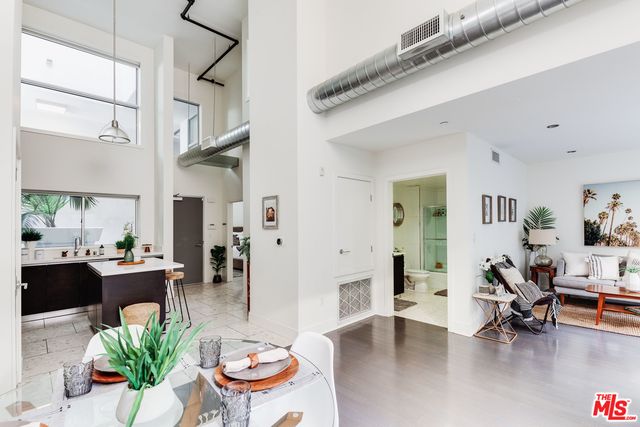 a living room with furniture and a dining table with kitchen view