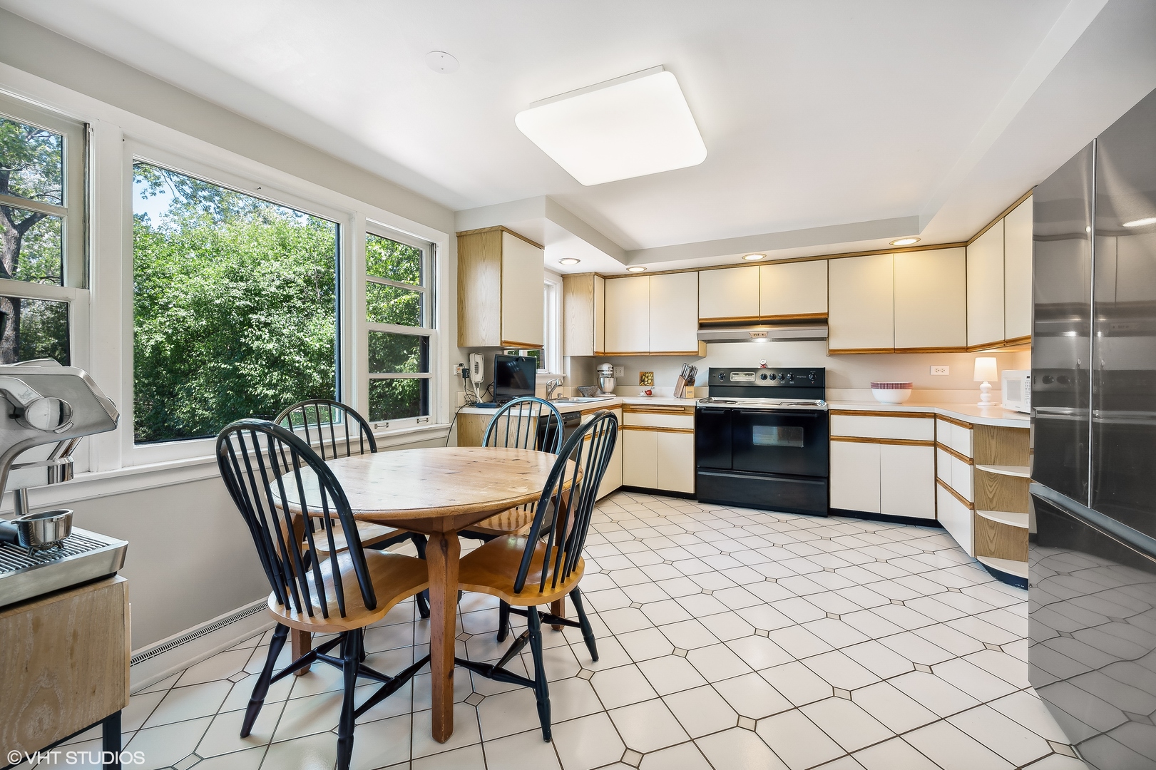 1544 Longvalley Road Glenview, IL 60025 - Photo 7 of 25 a kitchen with stainless steel appliances a table chairs sink refrigerator and cabinets