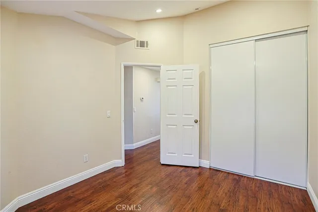 a view of a big room with wooden floor and windows