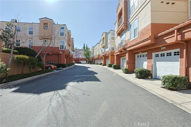 a view of a house with a yard and potted plants