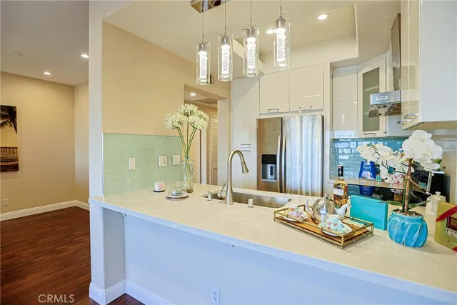 a view of a kitchen with refrigerator and wooden floor
