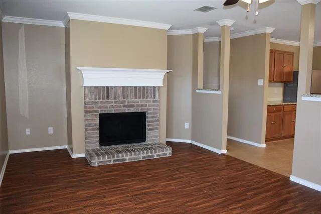 a view of a livingroom with wooden floor and a fireplace