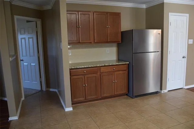 a kitchen with stainless steel appliances granite countertop a refrigerator and a stove