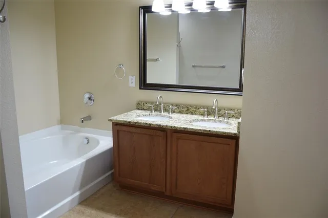 a bathroom with a tub sink and mirror