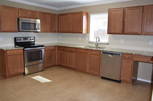 a kitchen with stainless steel appliances granite countertop a stove microwave and sink