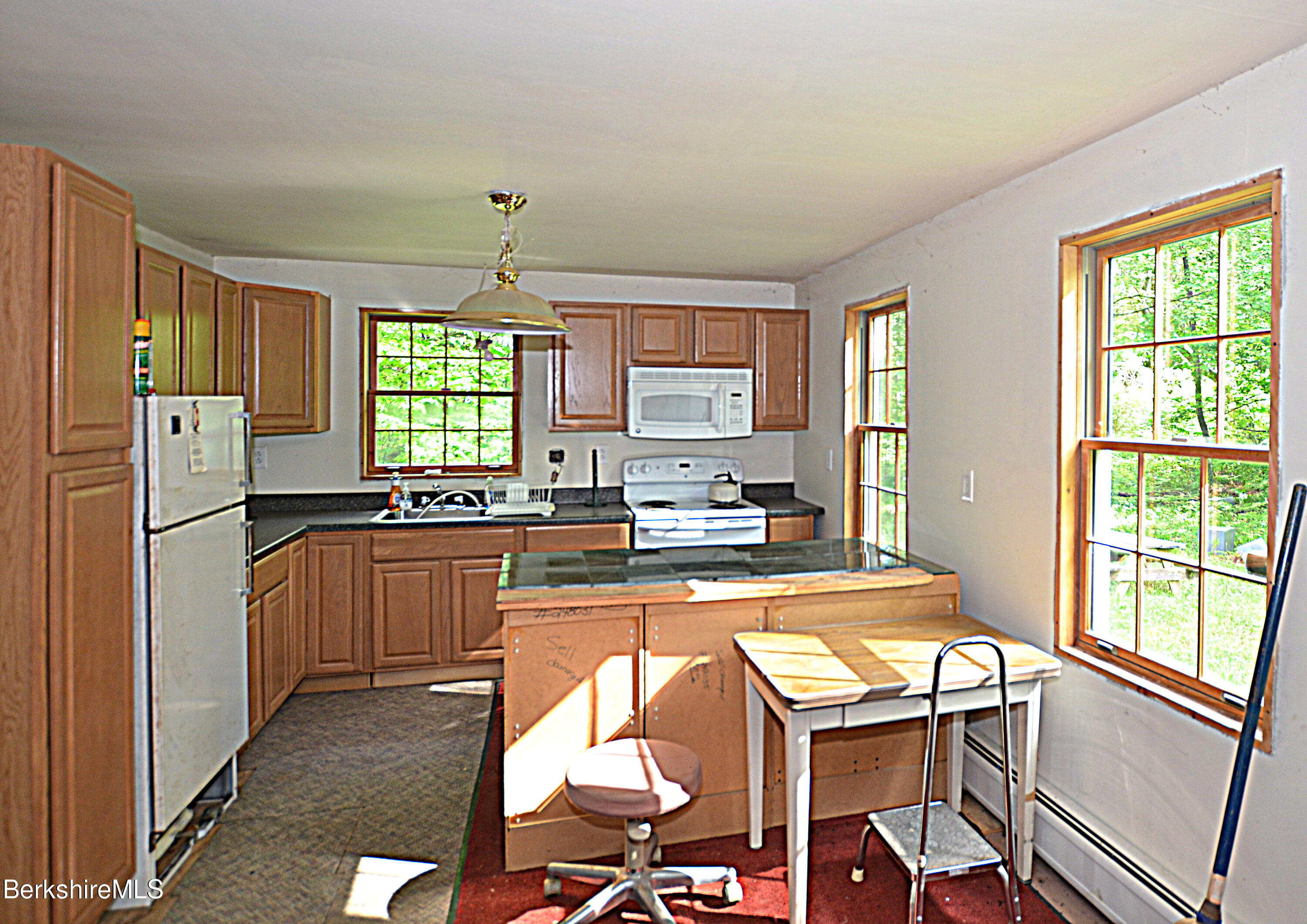 80 Town Hill Road Middlefield, MA 01011 - Photo 13 of 44 a kitchen with a refrigerator a stove a sink and dishwasher with a dining table